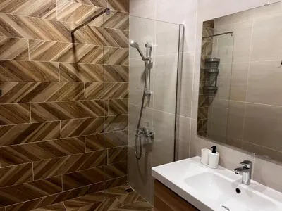 a bathroom with a shower and a sink and a mirror at Las Brisas Garden Apartment in Burgas City