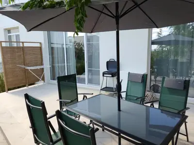 a table and chairs with an umbrella on a patio at Las Brisas Garden Apartment in Burgas City