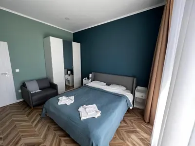 a blue bedroom with a bed and a chair at Las Brisas Garden Apartment in Burgas City