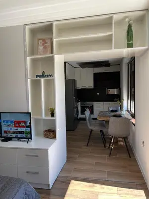 a bedroom with a living room with a desk and a kitchen at Studio Rêve in Burgas City
