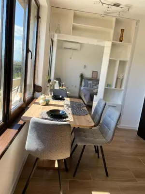 a dining room with a wooden table and chairs at Studio Rêve in Burgas City
