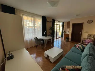a living room with a blue couch and a table at HELIOS I premium in Sveti Vlas