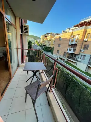 a table and a bench sitting on a balcony at HELIOS I premium in Sveti Vlas