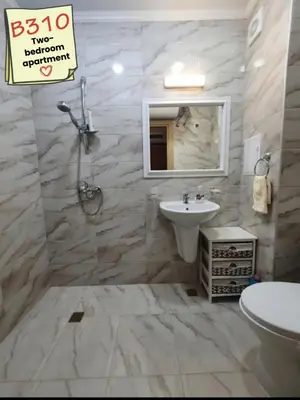 a bathroom with a sink and a toilet and a mirror at Apartments Vilma&Villiam in Ravda