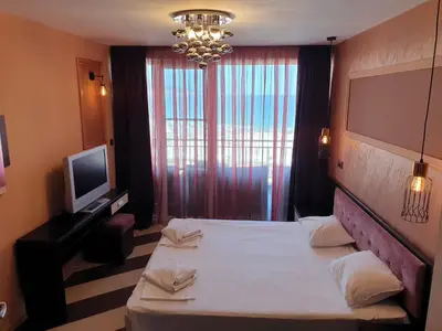 a hotel room with a bed and a television at Heaven Lux Apartments in Sunny Beach