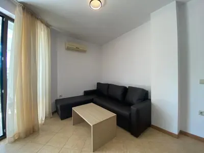 a living room with a black couch and a table at ROYAL SUN O 31 Apartment Royal Sun in Sunny Beach