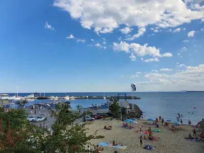 a group of people on a beach near the water at Sveti Vlas Marina Beach Apartment - Vega Village in Sveti Vlas