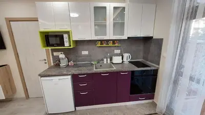 a kitchen with purple cabinets and a sink and a microwave at Sunrise City A1, Sarafovo in Burgas City