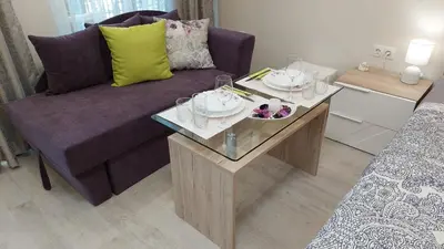 a living room with a purple couch and a coffee table at Sunrise City A1, Sarafovo in Burgas City