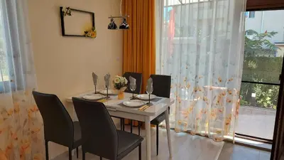 a dining room with a table and chairs and a window at Sunrise City A2, Sarafovo in Burgas City