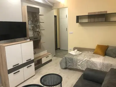 a living room with a bed and a flat screen tv at Sunrise City A2, Sarafovo in Burgas City