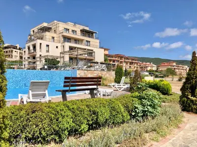 a bench and chairs in front of a building at Sorrento - Menada Apartments in Sveti Vlas