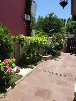 a garden with plants and flowers next to a building at The White Houses Complex in Nesebar