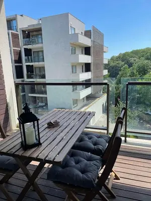 a wooden table and a chair on a balcony at YooBulgaria-Obzor SP apartments in Obzor
