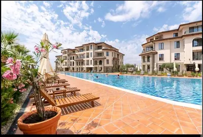 a swimming pool with benches and some buildings at LOVE apartment in Burgas City