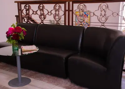 a black leather couch next to a table with a vase of roses at Effect Saint Mina in Sozopol