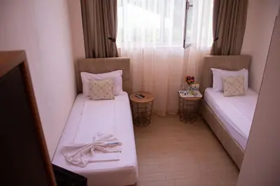 a small room with two beds and a window at Effect Saint Mina in Sozopol