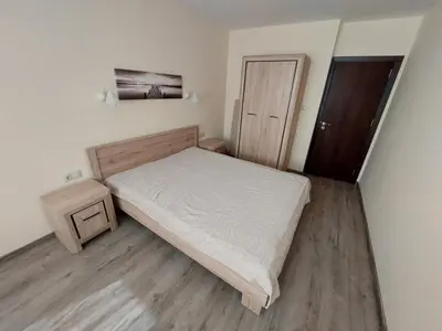 a small bedroom with a bed and a wooden floor at Апартаменти за гости Делукс in Burgas City