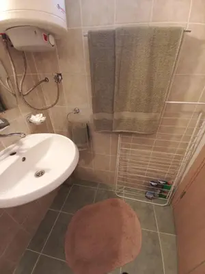 a bathroom with a sink and a toilet and towels at Венета 1 in Sozopol