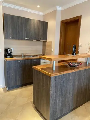 a kitchen with wooden cabinets and a counter top at AJ Apartment 1 with Pool view, Santa Marina Holiday Village, Sozopol in Sozopol