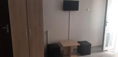 a room with a table and a tv on a wall at Къща за гости Симеонови in Sozopol