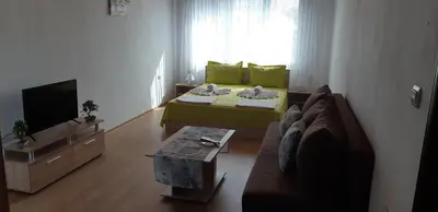 a living room with a couch and a television at Къща за гости Симеонови in Sozopol