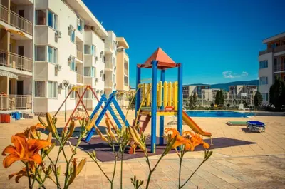 a playground in front of a building with a pool at 1-bedroom Apartment in a Resort with 6 Pools, Top Floor, Stunning Sunset View in Sunny Beach