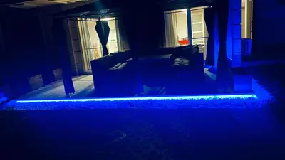 a dark room with a bed with blue lights at Свети Йоан in Sozopol