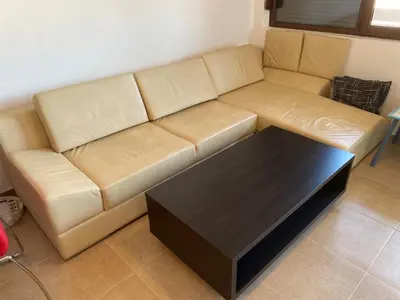 a brown couch in a living room with a coffee table at The modern apartment in the ancient city in Sozopol