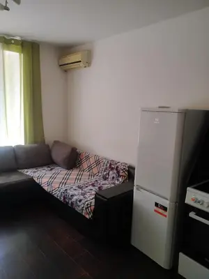 a small room with a couch and a refrigerator at Хаджи Иванов in Varna City