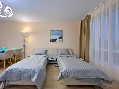 a bedroom with two beds and a table and a dining room at Premium Apartment Villa Aristo in Sveti Vlas