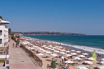 a beach with many umbrellas and people on the beach at Casa del Mar Apartment in Obzor