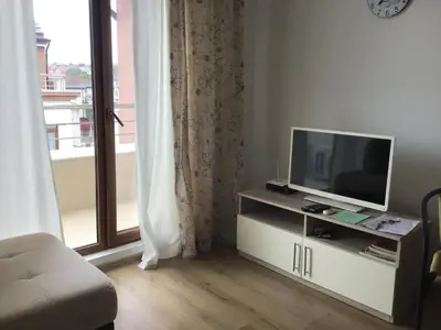 a living room with a television and a window at Casa del Mar Apartment in Obzor