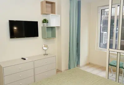 a room with a dresser and a tv on a wall at The Blue Apartment - 1BD with a Cozy Balcony by Flat Mаnager in Varna City