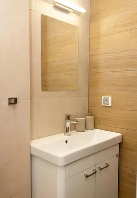a bathroom with a white sink and a mirror at The Blue Apartment - 1BD with a Cozy Balcony by Flat Mаnager in Varna City