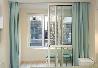 a bedroom with a window with blue curtains at The Blue Apartment - 1BD with a Cozy Balcony by Flat Mаnager in Varna City