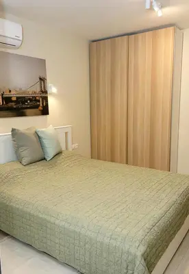 a bedroom with a bed and a wooden closet at The Blue Apartment - 1BD with a Cozy Balcony by Flat Mаnager in Varna City