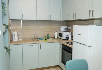 a kitchen with white cabinets and a white refrigerator at The Blue Apartment - 1BD with a Cozy Balcony by Flat Mаnager in Varna City