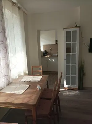 a dining room with a wooden table and chairs at Apartment Starfish in Varna City