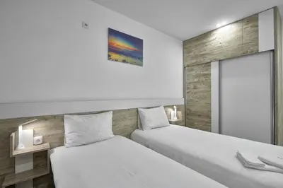 two beds in a hotel room with at Weiss Estate by EstateAutomata in Burgas City