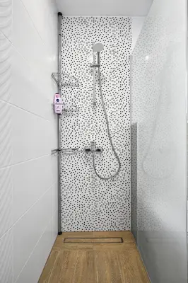 a bathroom with a shower with black and white tiles at Weiss Estate by EstateAutomata in Burgas City
