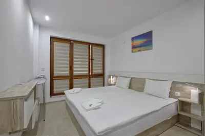 a white bedroom with a bed and a desk at Weiss Estate by EstateAutomata in Burgas City