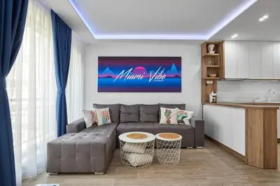 a living room with a couch and a kitchen at Miami Vibe by EstateAutomata in Burgas City