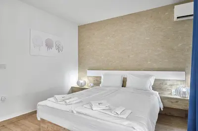 a bedroom with a white bed with two towels on it at Miami Vibe by EstateAutomata in Burgas City