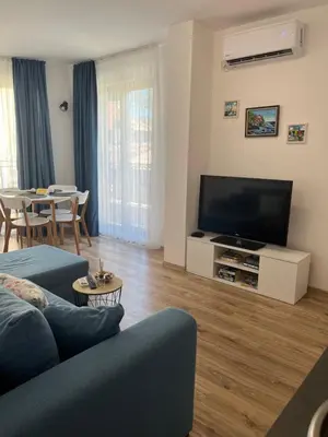 a living room with a couch and a flat screen tv at Azzurro Premium Apartment on Bulevard Bogoridi in Burgas City