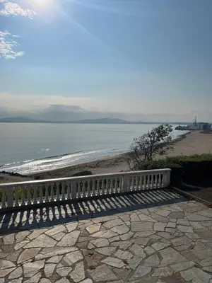 a white bench sitting on top of a beach at Azzurro Premium Apartment on Bulevard Bogoridi in Burgas City