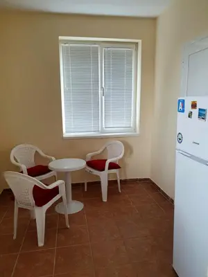 a kitchen with a table and chairs and a refrigerator at Viriks in Burgas City