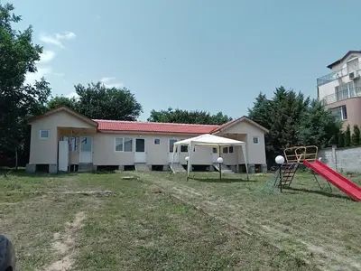 a playground in front of a house at Krimski Guest House and Bungalows in Byala