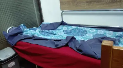 a bed with a red and blue comforter on it at Стаи на пъпа на Варна, входа на Морската градина in Varna City