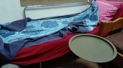 a mirror sitting next to a bed with a blanket at Стаи на пъпа на Варна, входа на Морската градина in Varna City
